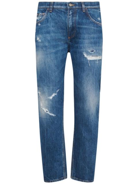 Distressed denim five pocket jeans