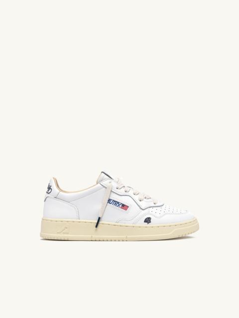 AUTRY MEDALIST LOW SNEAKERS IN WHITE LEATHER WITH SPACE BLUE DETAILS