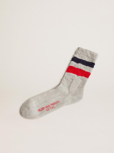 Gray socks with contrasting red and blue stripes and red logo