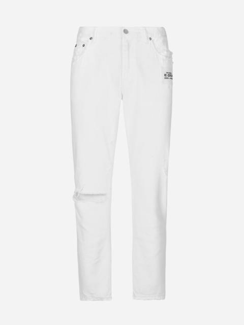 Loose white jeans with rips and abrasions