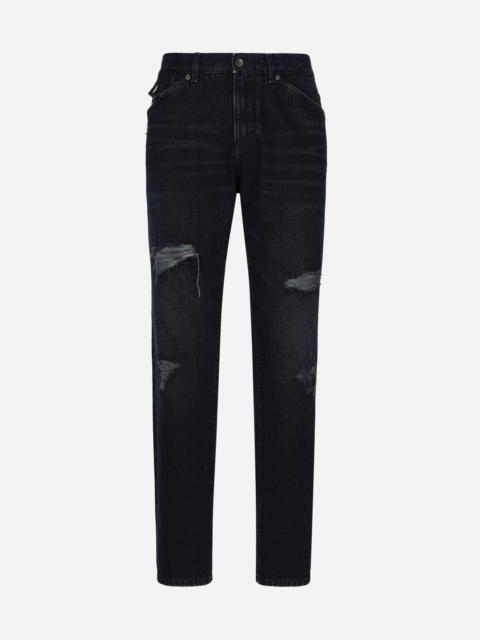Blue denim jeans with abrasions and rips