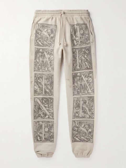 SAINT M×××××× + Denim Tears Tapered Printed Distressed Cotton-Jersey Sweatpants