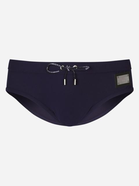Swim briefs with high-cut leg and branded plate