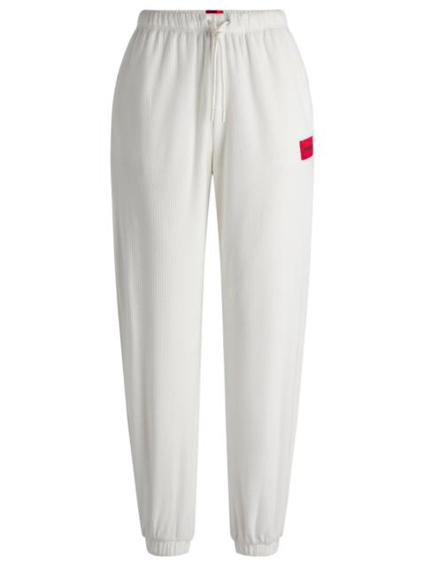 HUGO TRACKSUIT BOTTOMS WITH RED LOGO LABEL