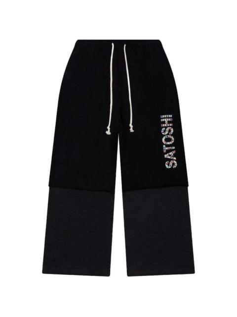 SATOSHI NAKAMOTO double-layer studded track pants