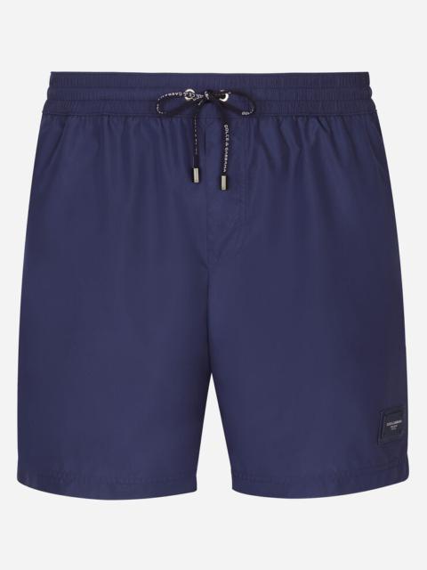Mid-length swim trunks with branded plate