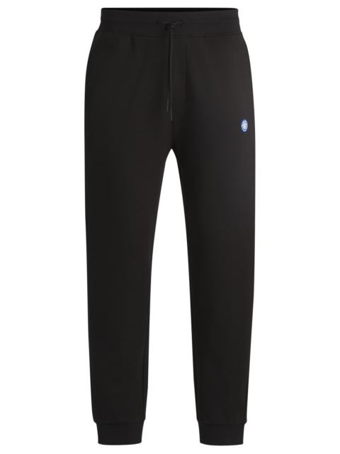HUGO COTTON-TERRY TRACKSUIT BOTTOMS WITH HAPPY HUGO LOGO PATCH