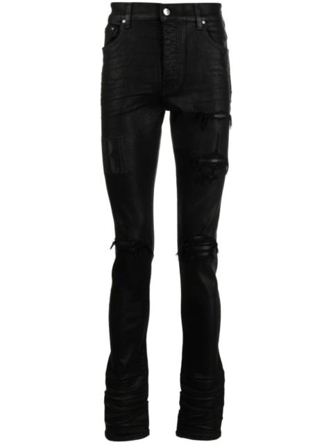 AMIRI logo-embroidered distressed slim-cut jeans