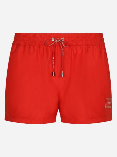 Short swim trunks with branded plate