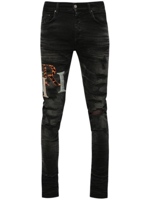 AMIRI logo-patch distressed skinny jeans