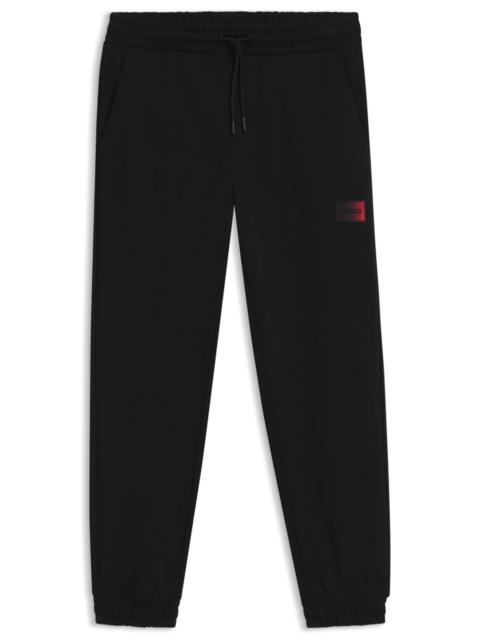 HUGO GRADIENT-LOGO TRACKSUIT BOTTOMS IN COTTON TERRY