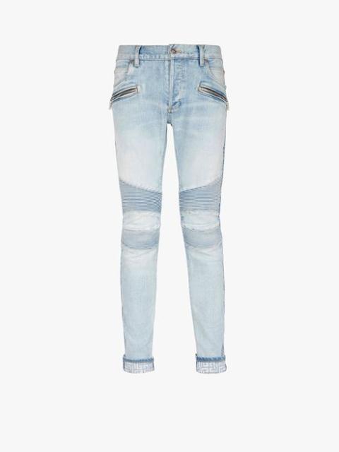 Slim cut faded and ridged light blue denim cotton jeans with Balmain monogram on hem