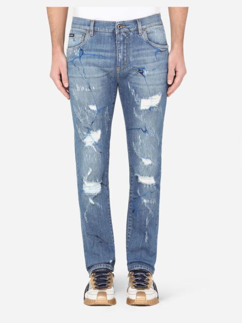 Washed blue skinny stretch jeans with rips and brushstrokes