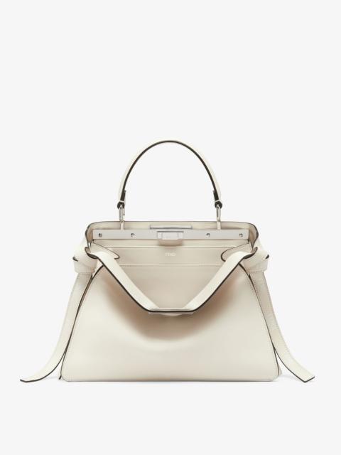 FENDI Iconic medium Peekaboo ISeeU bag, made of off-white leather with long knotted side laces, printed wi